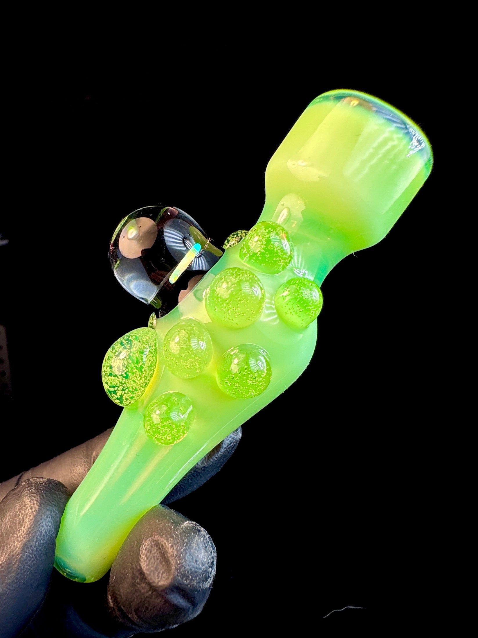 Side view of Slyme green glass chillum with an opal and Slyme green dots